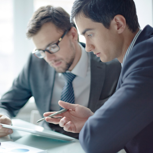 Two businessmen evaluating documents.